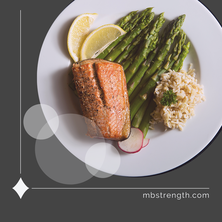 Healthy dinner of salmon, rice and asparagus, on a white plate.